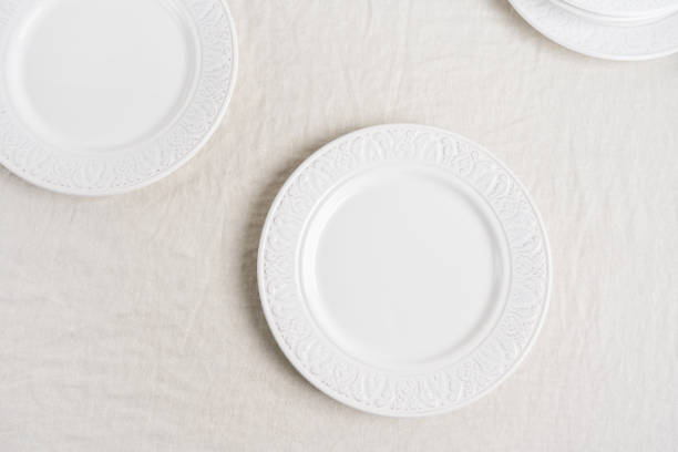 istock Preparation to the table setting with white empty plates on linen tablecloth with copy space.  Concept food table serving. 1191406692