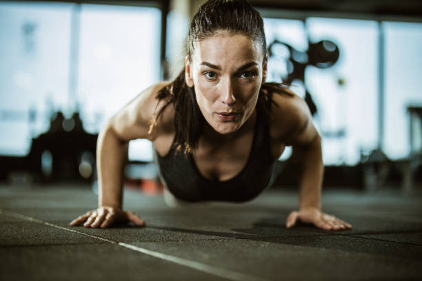 istock Determined athletic woman exercising push-ups in a gym. 1191406835
