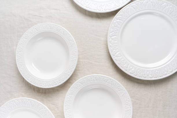 istock Preparation to the table setting with white empty plates on linen tablecloth with copy space.  Concept food table serving. 1191407944
