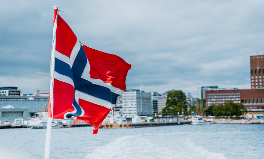 Norway flag on the ferry, view of Oslo city hall, Scandinavia