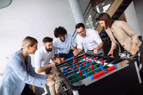 istock Happy young office workers playing table football 1191408476