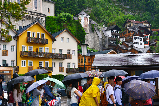 Hallstatt, Austria - June 6, 2019: Queue of tourists on a ferry on a rainy day in Hallstatt.