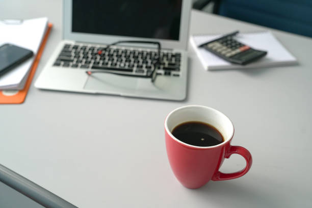 istock Office table with laptop calculator and focus on coffee in red cup 1191409591