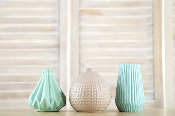 istock Different ceramic vases on wooden background 1191409782