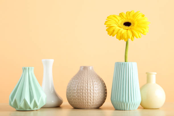 istock Different ceramic vases and gerbera flower on beige background 1191409793