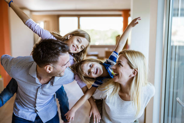 istock Playful family having fun while piggybacking at new home. 1191410247