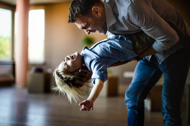 playful single father having fun with his son at their new home. - tickling imagens e fotografias de stock