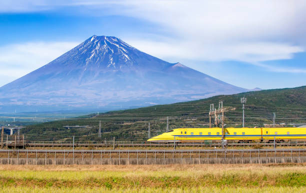 Yellow High Speed Bullet Train passing Fuji Mountain background, Shizuoka, Japan Japan - November 17, 2019 : Yellow High Speed Bullet Train passing Fuji Mountain background, Shizuoka, Japan bullet train mount fuji stock pictures, royalty-free photos & images