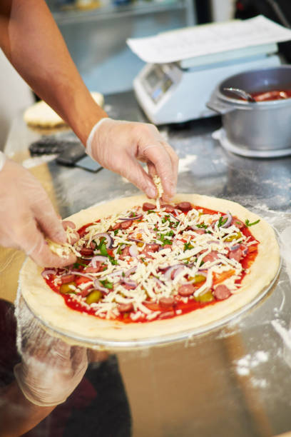 istock Hand of chef baker making pizza at kitchen of pizzeria 1191411521