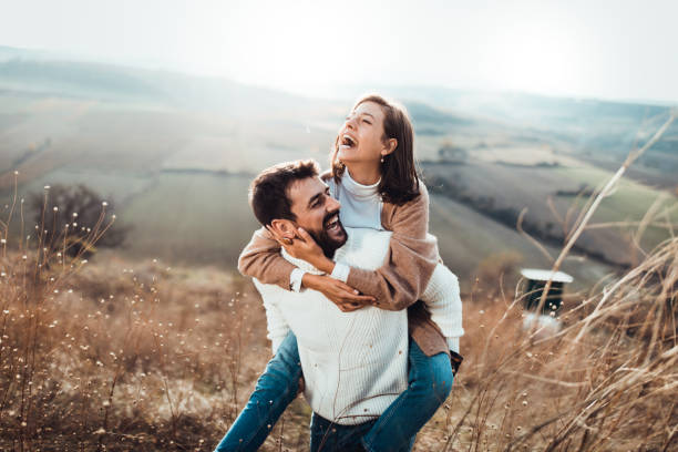 istock Young cheerful couple having fun while piggybacking on a hill. 1191412590