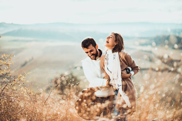 istock Young cheerful couple having fun while walking in a meadow. 1191412753
