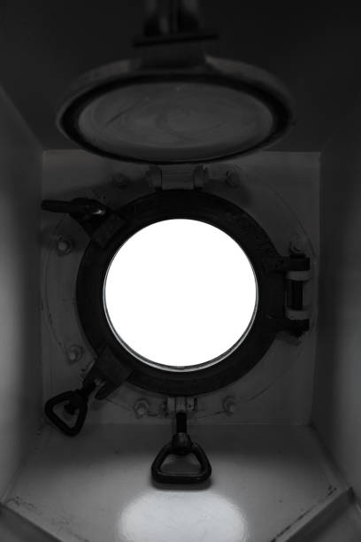 Open round porthole in dark ship cabin wall with empty white space outside