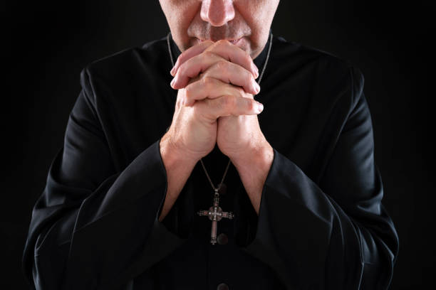 istock Priest pastor praying with hands on black 1191417338