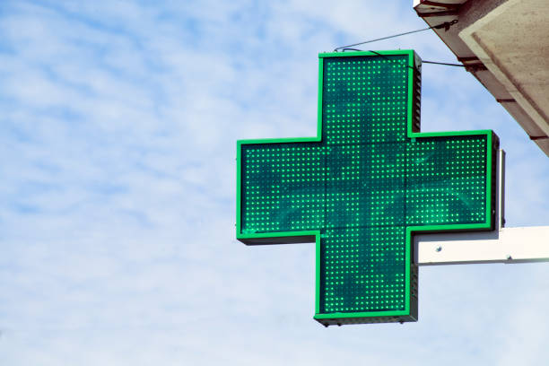 istock Pharmacy symbol and green cross, blue sky background. 1191417547