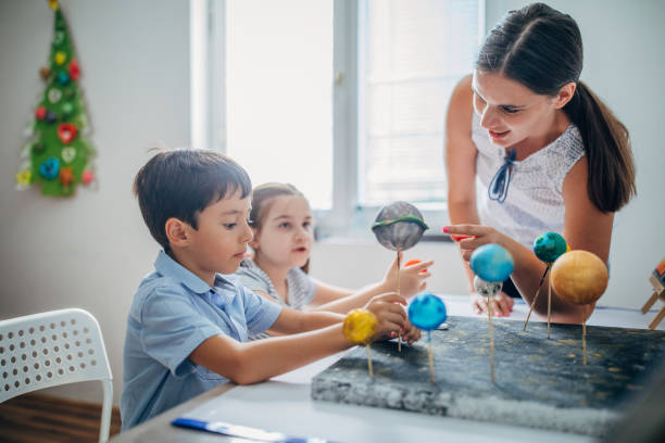 istock Teacher and two children on  science class in private elementary school 1191418593