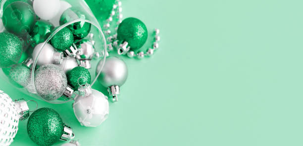 istock Christmas baubles in a wine glass on a light green background 1191420010