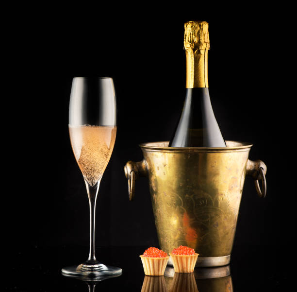 ボトルに入った赤いキャビアとシャンパン、黒い背景にグラス - champagne celebration glass black ストックフォトと画像
