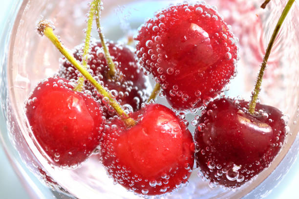 Cherry and bubbles in sparkling water stock photo