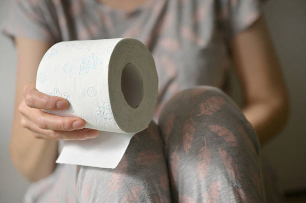 Woman Hand Holding Her Bottom And Toilet Paper Roll stock photo