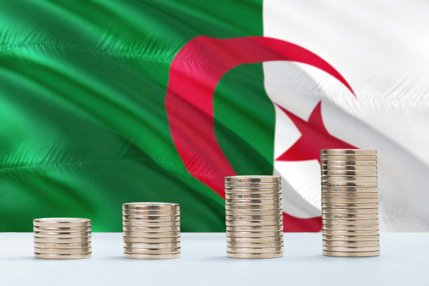 bandeira de argélia que acena no fundo com fileiras das moedas para a finança e o conceito do negócio. economizando dinheiro. - algerian currency - fotografias e filmes do acervo
