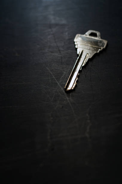istock Silver house key on wooden background 1191421753