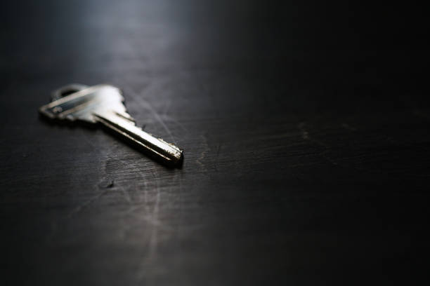 istock Silver house key on wooden background 1191421783