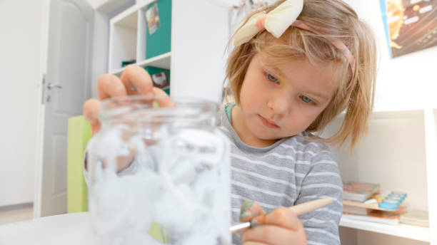 istock Girl painting on jar 1191423383