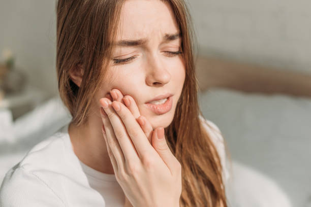 istock young woman touching cheek while suffering from toothache 1191423713