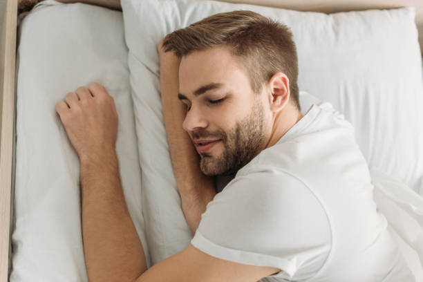 istock top view of young man smiling while sleeping on white bedding 1191423775