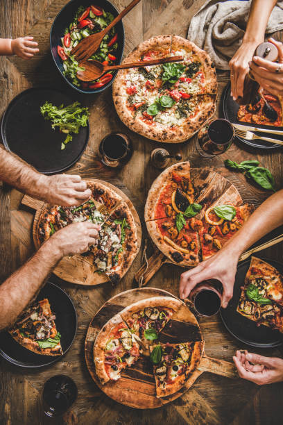 istock Family having pizza dinner party with red wine, top view 1191423875