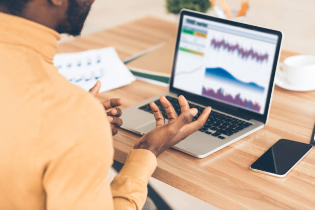 istock Stressed afro businessman looking at graphs on screen 1191424861