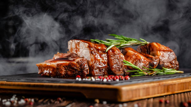 american food concept. grilled pork ribs with grilled sauce, with smoke, spices and rosemary. background image. copy space - close up roasted meal pepper imagens e fotografias de stock