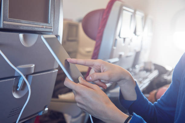 istock Woman using cellphone in modern airplane seat. 1191428123