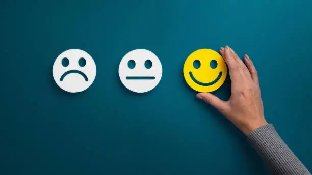 Photo of Woman choosing happy smiley face emotion on green