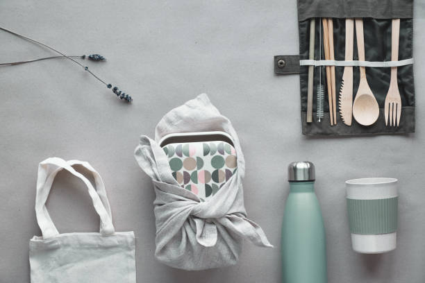 istock Creative top view, zero waste packed lunch kit, takeaway lunch box set on cotton bag, organizer of bamboo cutlery, reusable box and bamboo coffee cup. Sustainable lifestyle flat layout on craft paper. 1191429148