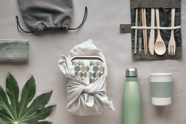 istock Creative top view, zero waste packed lunch kit, takeaway lunch box set on cotton bag, organizer of bamboo cutlery, bamboo lunch box and reusable cup. Sustainable lifestyle, flat layout on craft paper. 1191429243