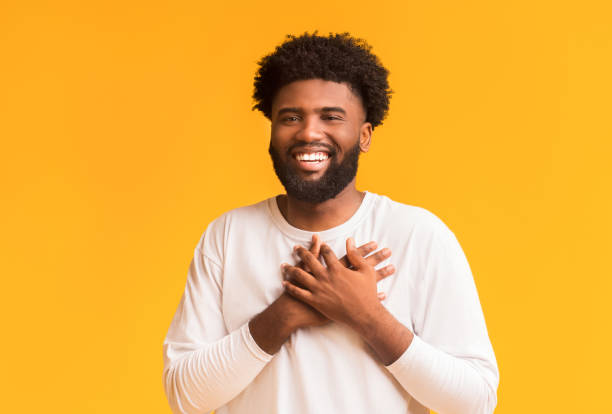 istock Smiling african man placing hands together next to heart 1191429461