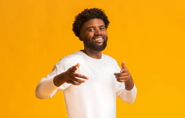 istock Cheerful black man greeting happily, indicating to camera 1191429551