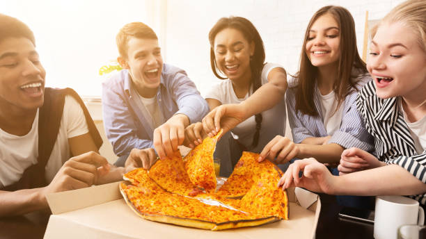 istock Lunch delivery. Friends taking pizza slices, panorama 1191429592