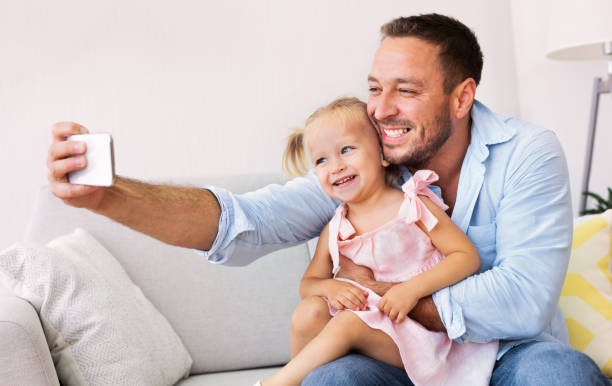 istock Smiling dad and little girl taking selfie 1191429647