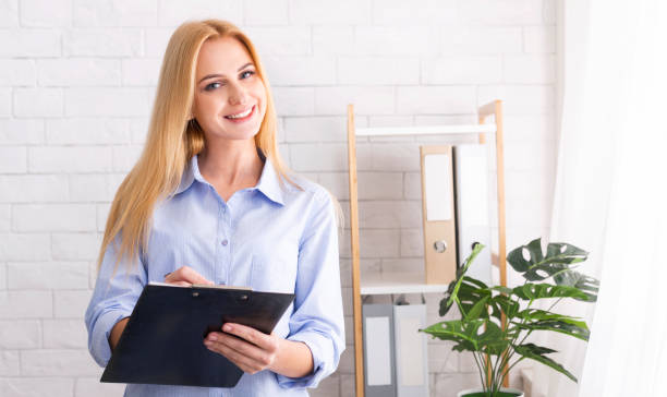 istock Friendly life coach standing with clipboard in office 1191431476