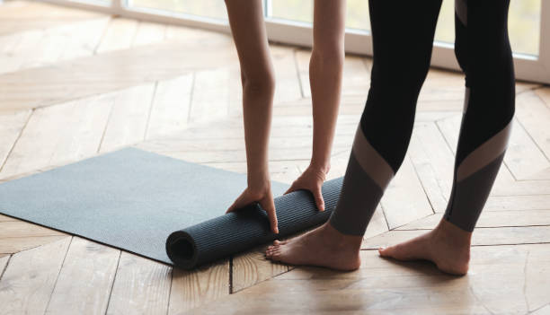 istock Woman rolling yoga mat, completing her practice 1191431543
