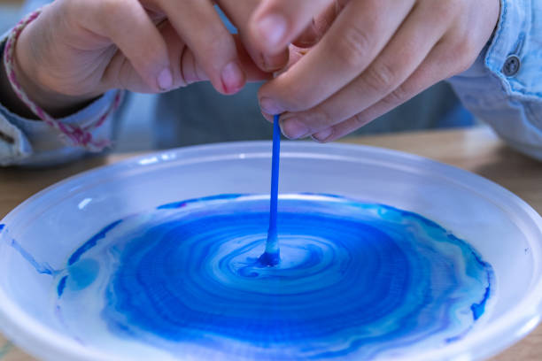 istock Girl doing colour changing milk experiment in the laboratory 1191433402