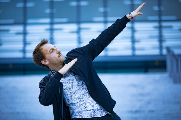 Young Adult Man Gesturing or Dancing Pointing Hands Up
