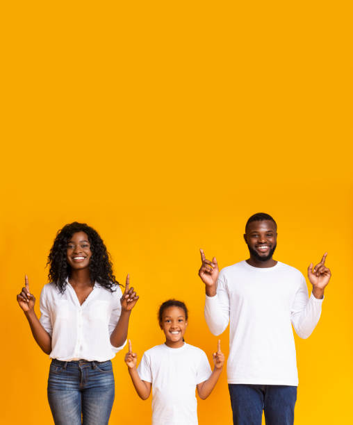 istock Happy family pointing upwards at copy space and looking at camera 1191434575
