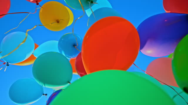 SLO MO LD Many colourful balloons released into the blue sky