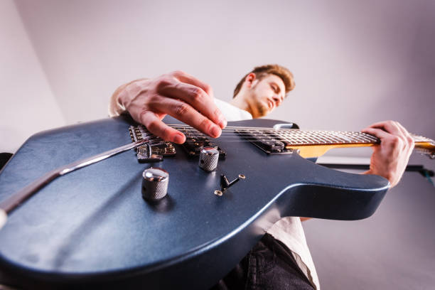 Detail of a woman's hand playing an electric guitar.