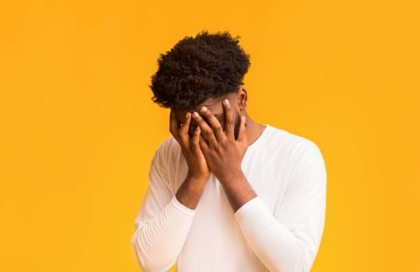 istock Young afro guy covering his face with both hands 1191436296