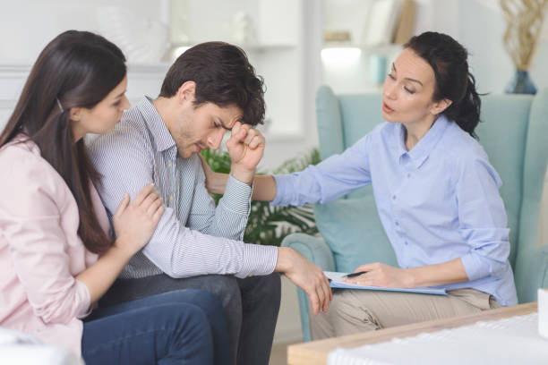 istock Psychologist and young woman supporting upset man during therapy 1191438677
