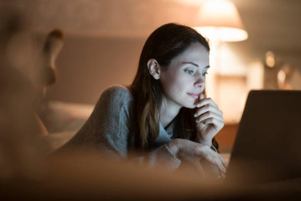istock Bed laptop evening woman 1191442086